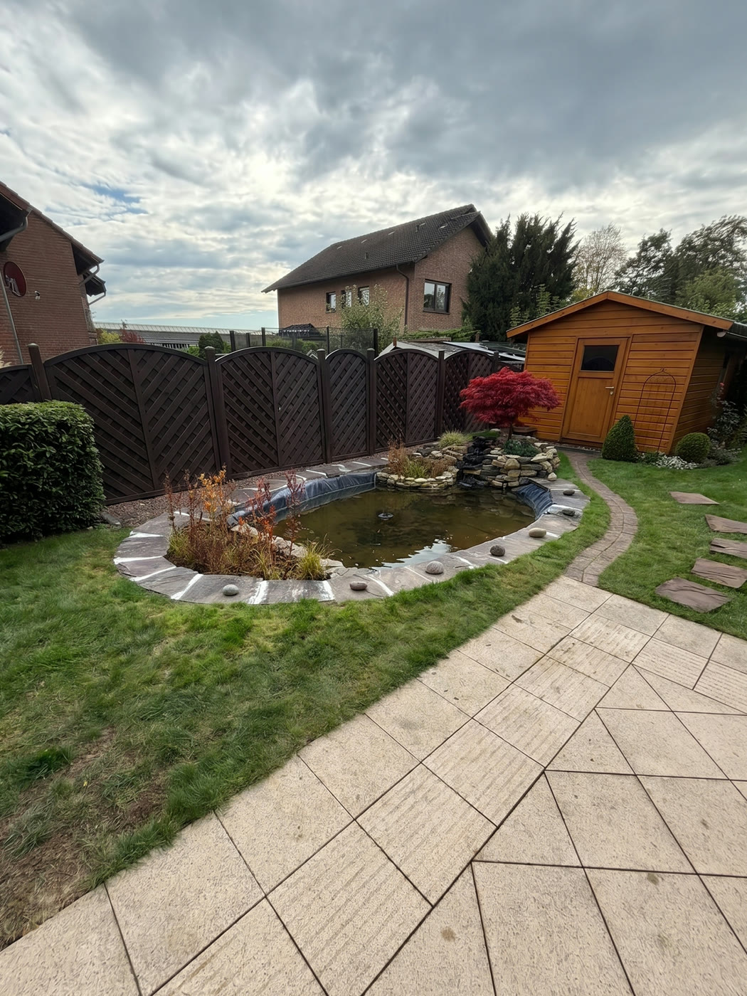 Fertig umgestalteter Gartenteich mit Natursteinrand